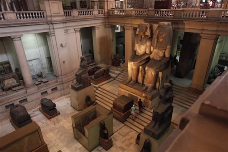 Tourists walk by the colossal Pharaonic statuary group of Amenhotep III and his family that is surrounded with security monitoring cameras at the great hall of the Egyptian Museum in Cairo, Egypt on Tuesday, Aug. 24, 2010. Security for Egypt's cultural treasures is under scrutiny after the Aug. 21, 2010 theft of a van Gogh painting from Cairo's Mahmoud Khalil Museum museum revealed some alarming gaps. (AP Photo/Nasser Nasser)
